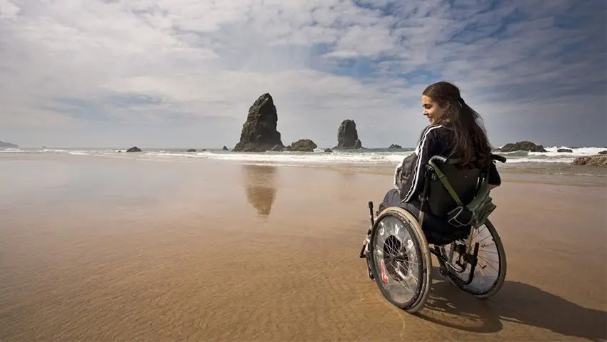 mujer en silla de ruedas en una playa