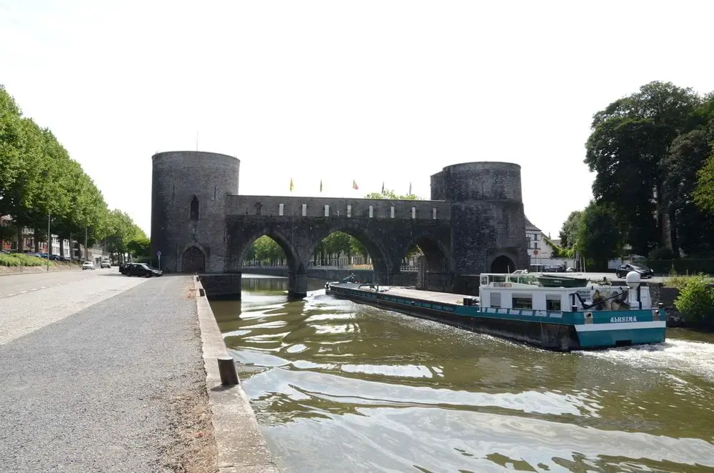 un bote pasa por uno de los desaparecidos arcos del puente de Tournai
