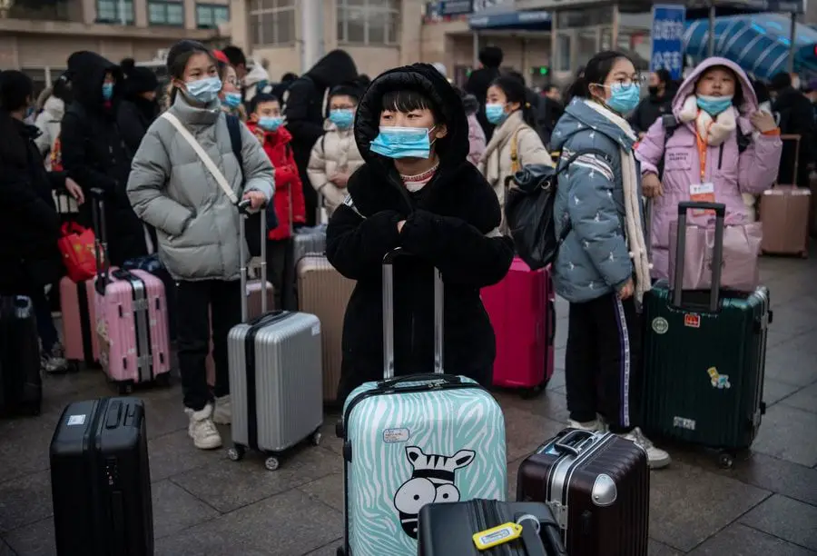 Grupo de viajeras de origen asiático usando tapabocas en un aeropuerto