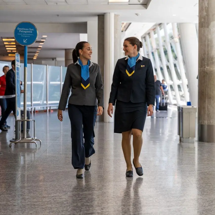 Dos empleadas de Aerolíneas Argentinas, una de falda y otra de pantalón