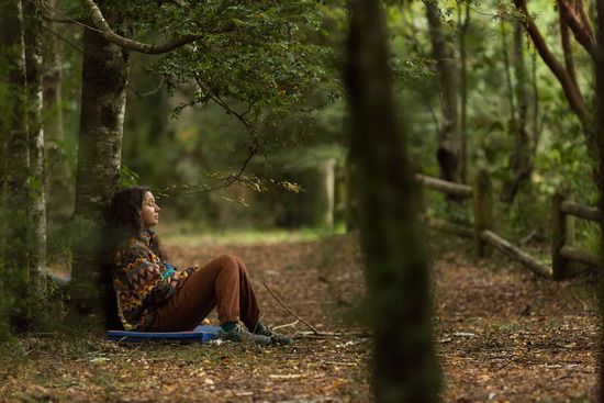 Mujer relajándose en un bosque de la Patagonia