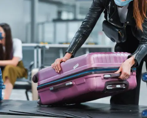 Una mujer recoge su maleta en el área de reclamo de equipaje de un aeropuerto