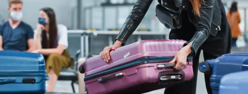 Una mujer recoge su maleta en el área de reclamo de equipaje de un aeropuerto
