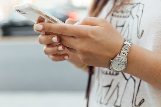 Foto de Paul Hanaoka de mujer texteando en un celular